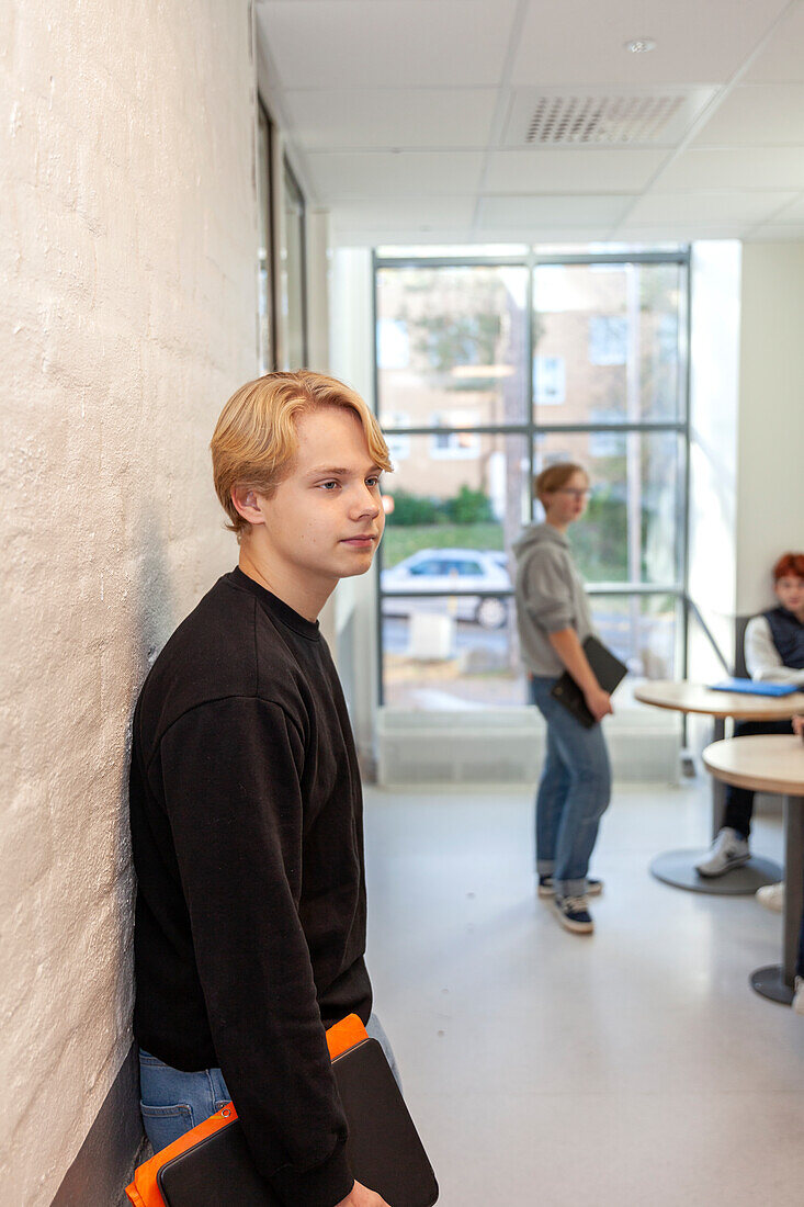 Teenage boy standing on school corridor