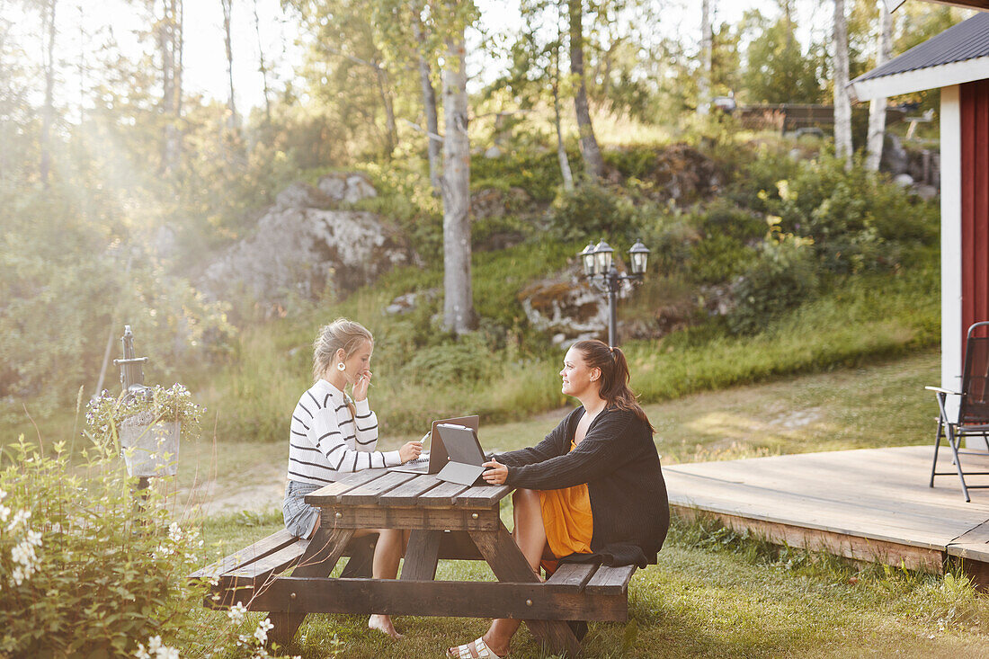 Female friends sitting on picnic bench