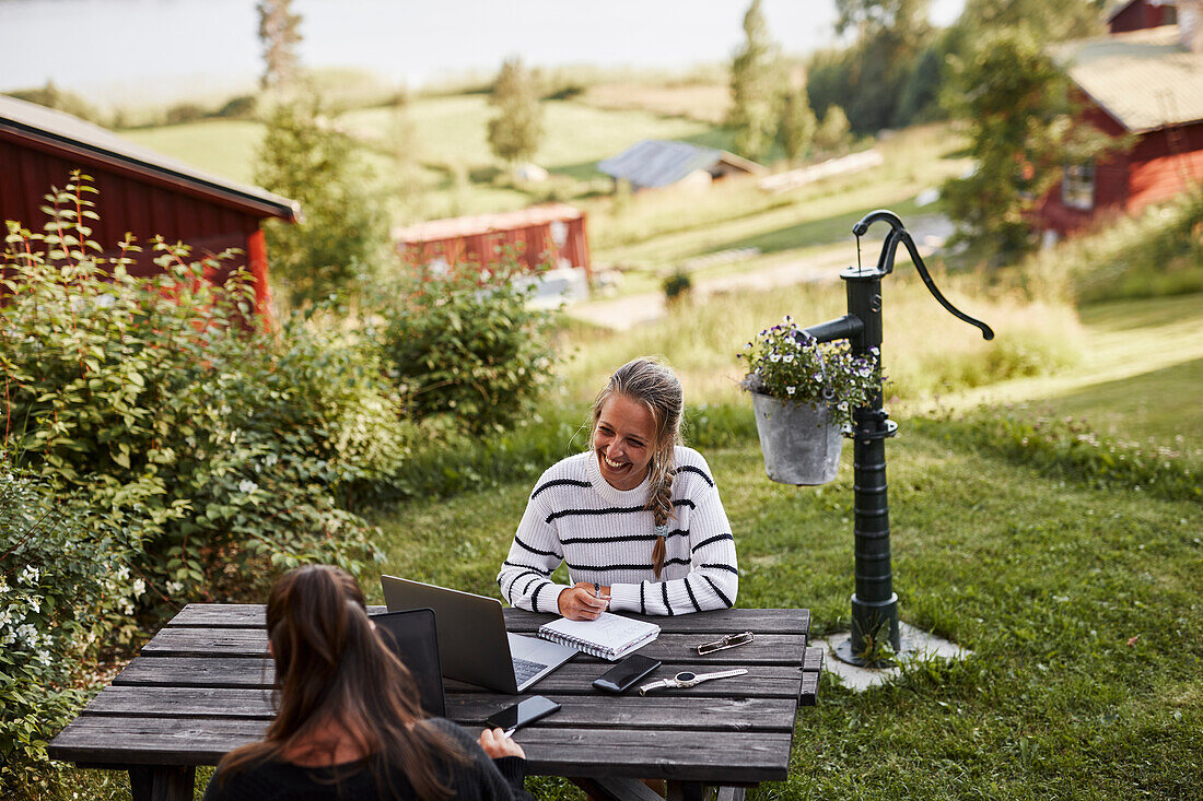 Freundinnen sitzen auf einer Picknick-Bank