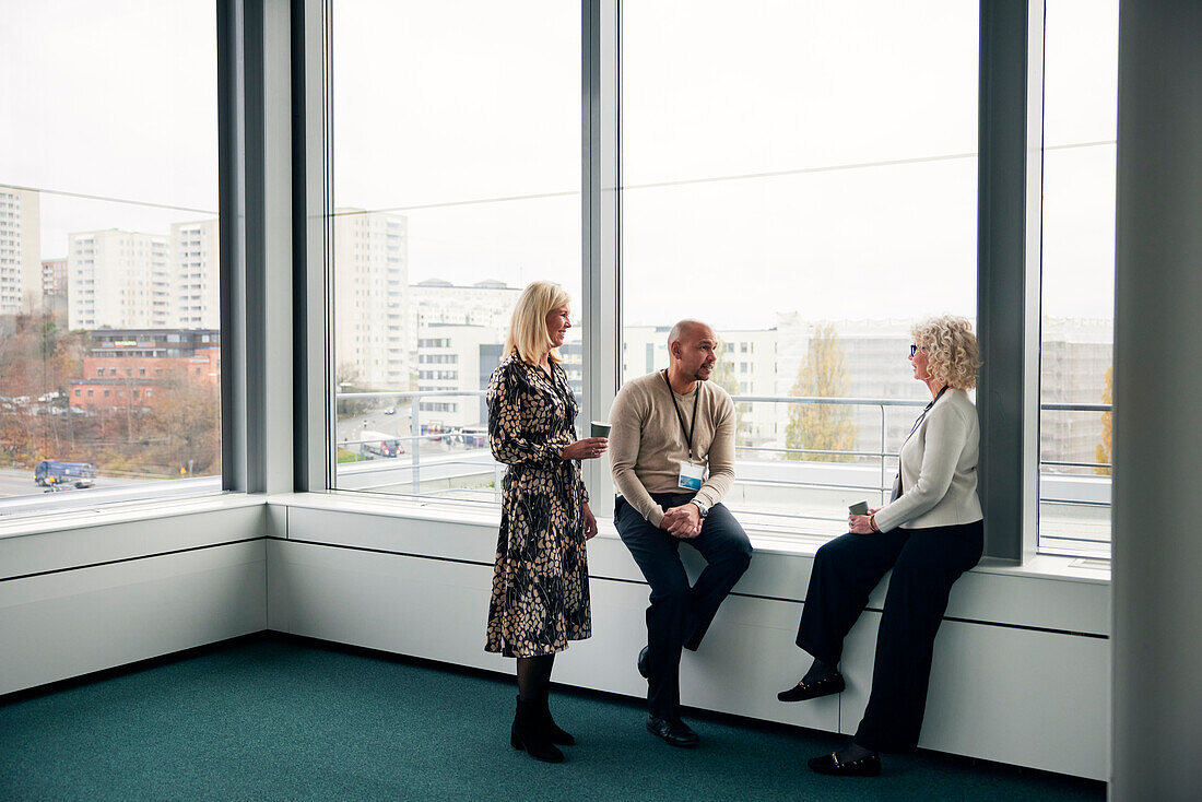 Geschäftsleute unterhalten sich in der Kaffeepause im Büro