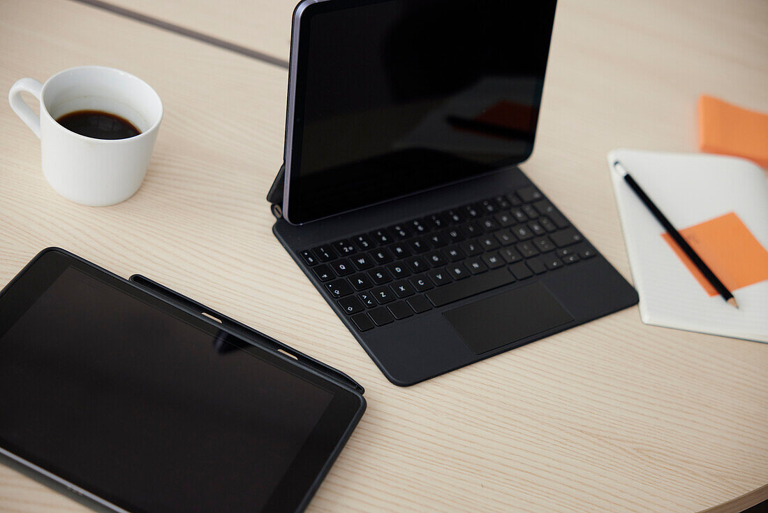 Digitales Tablet und Notizblock auf dem Schreibtisch im Büro