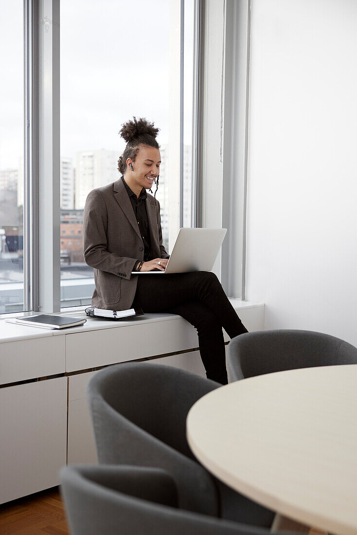 Young businessman working on laptop in office