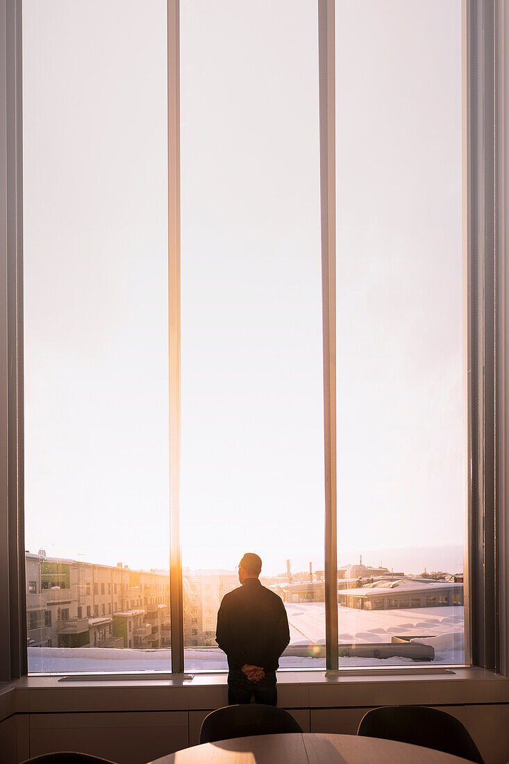 Businessman looking through office window