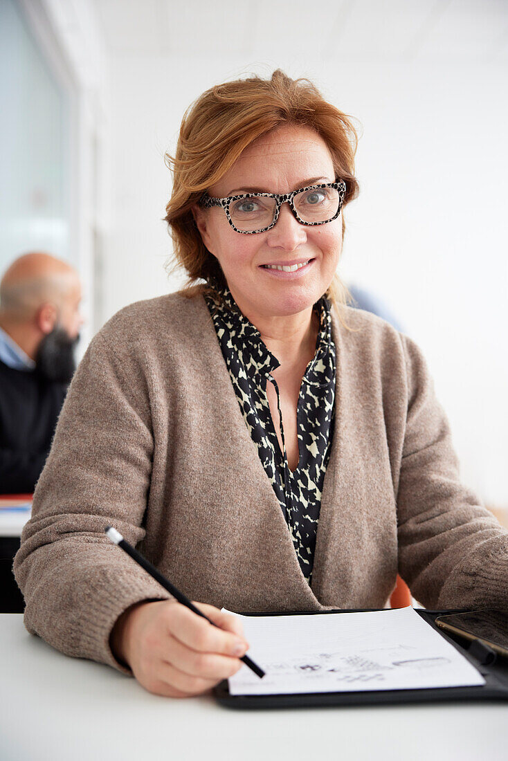 Smiling woman taking notes during workshop