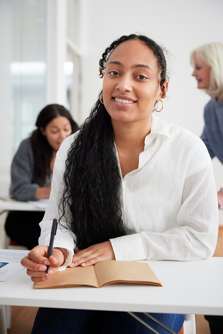 Smiling woman taking notes during workshop