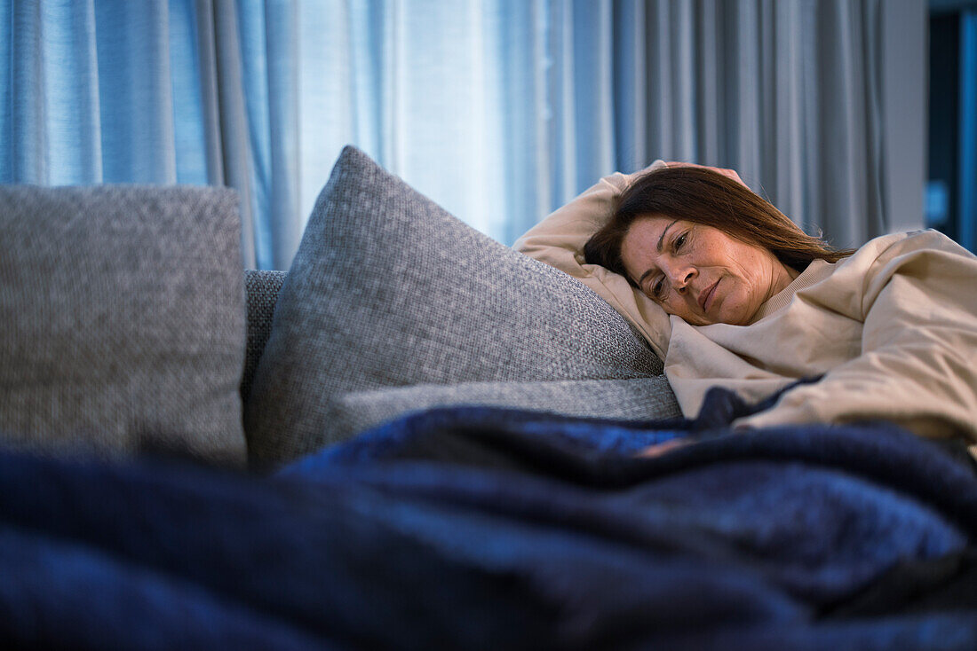 Ill woman lying on sofa