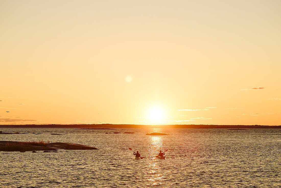 Two men kayaking at sunset