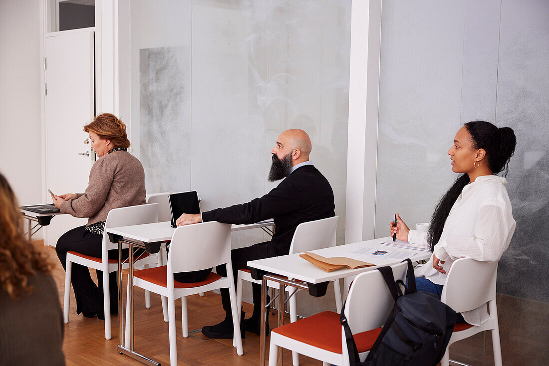 Menschen sitzen im Seminar