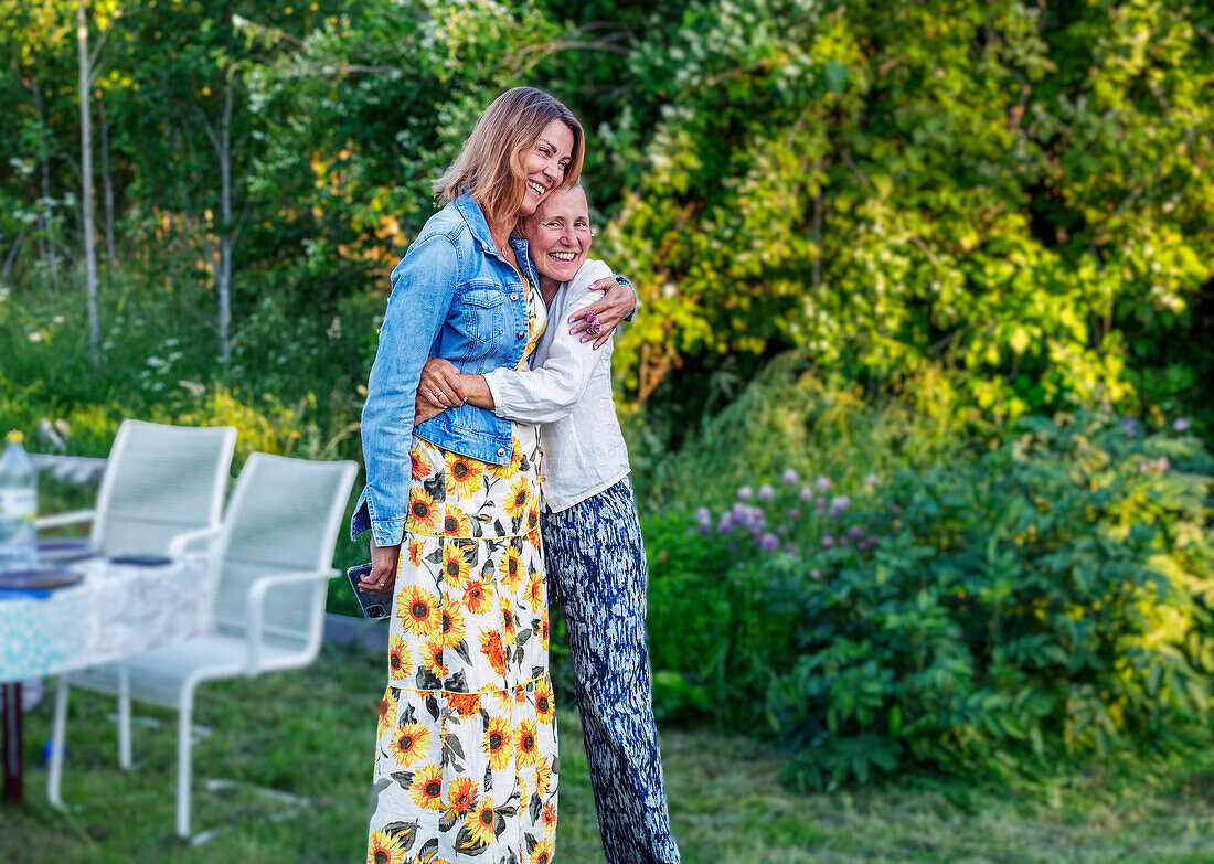 Mother and daughter hugging in garden