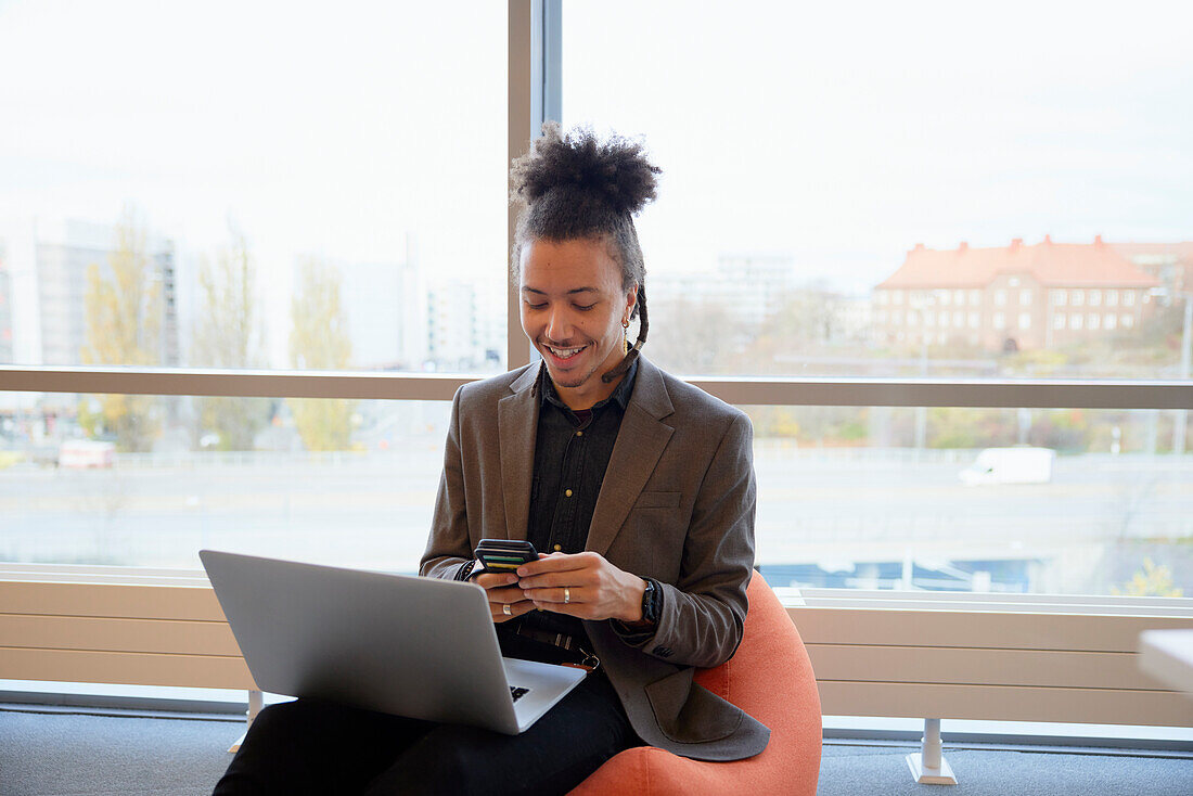 Mann im Büro mit Mobiltelefon