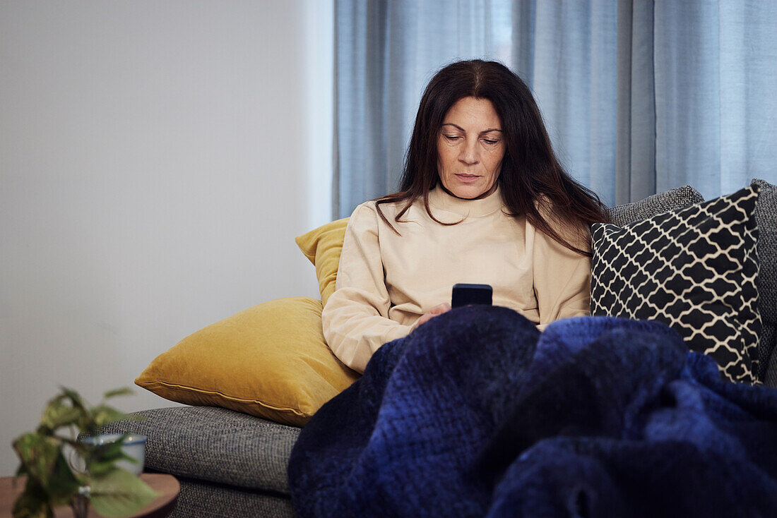 Woman on sofa using cell phone