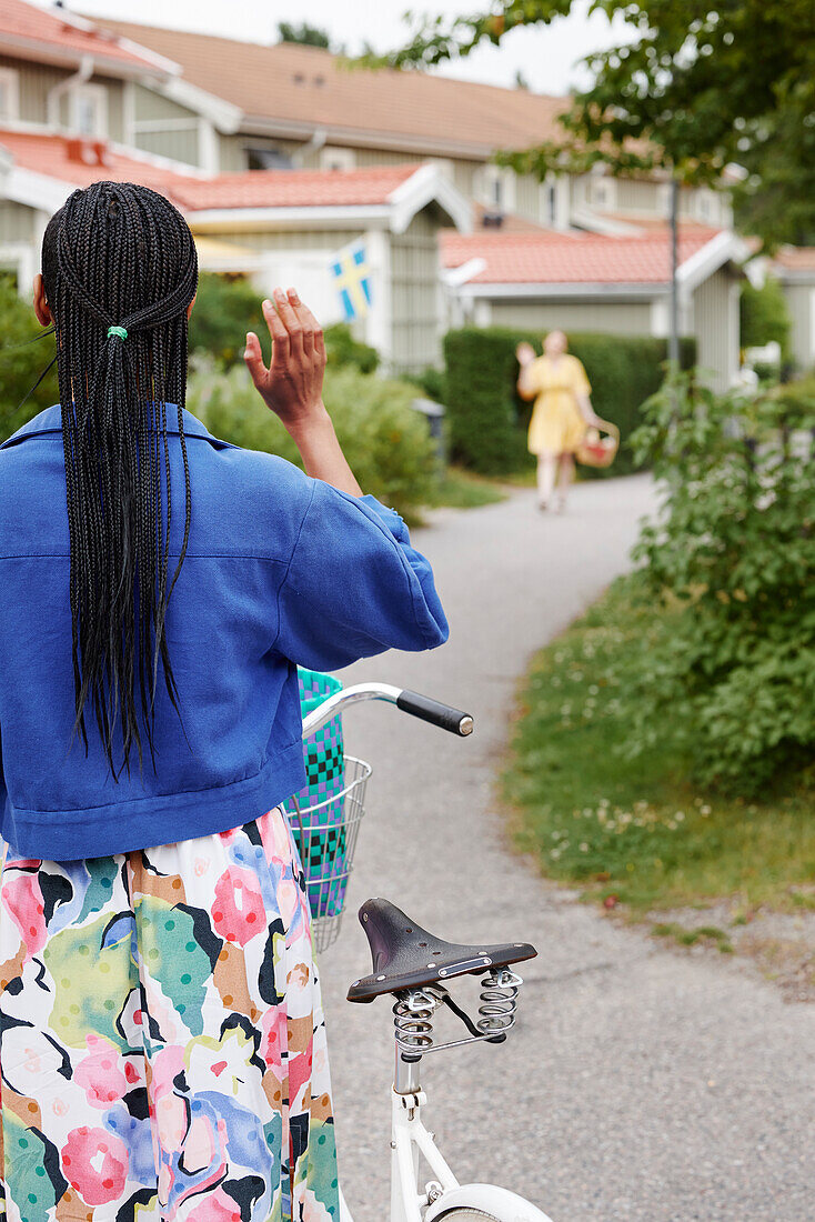 Rear view of woman standing near bicycle