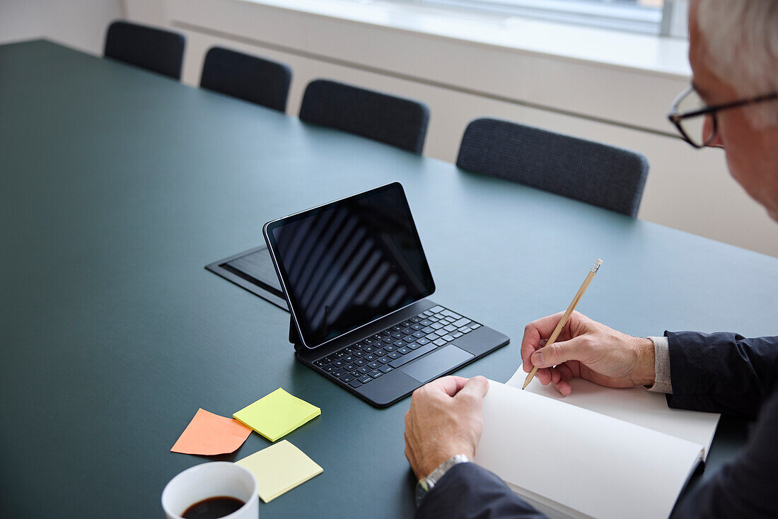 Businessman making notes in diary