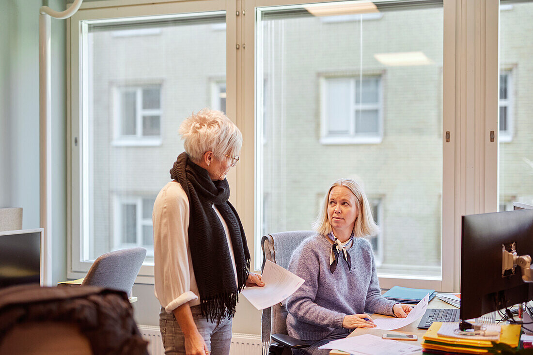Frauen unterhalten sich im Büro miteinander