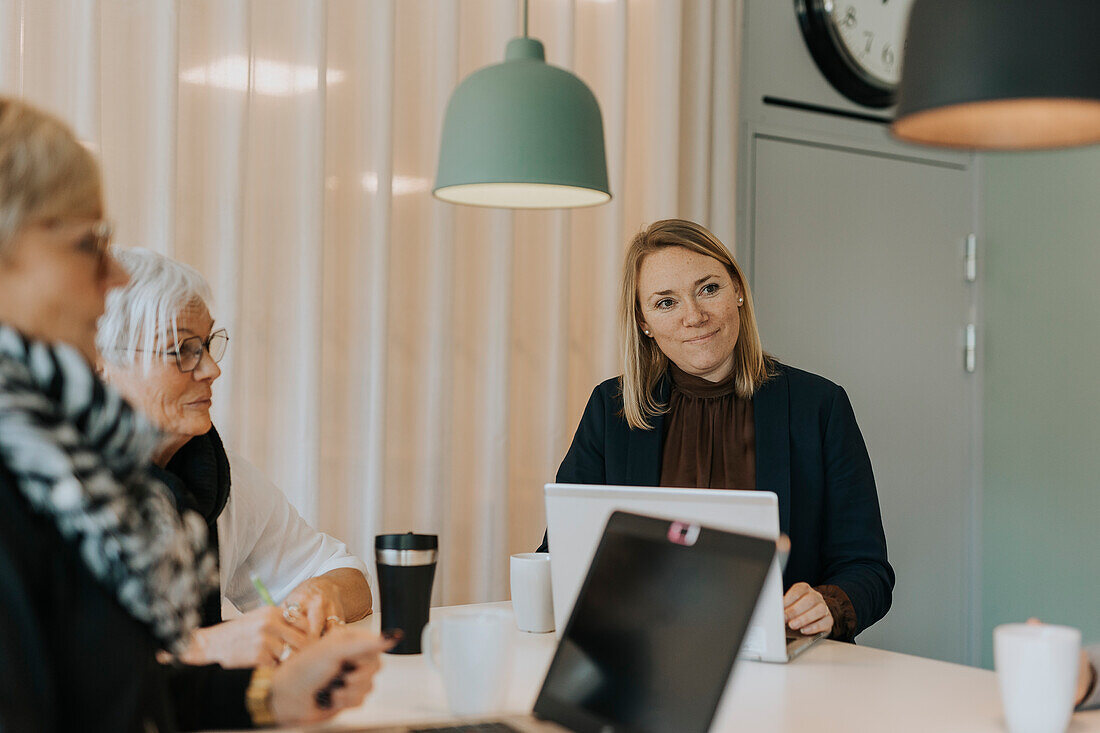 Lächelnde Frauen im Gespräch im Büro