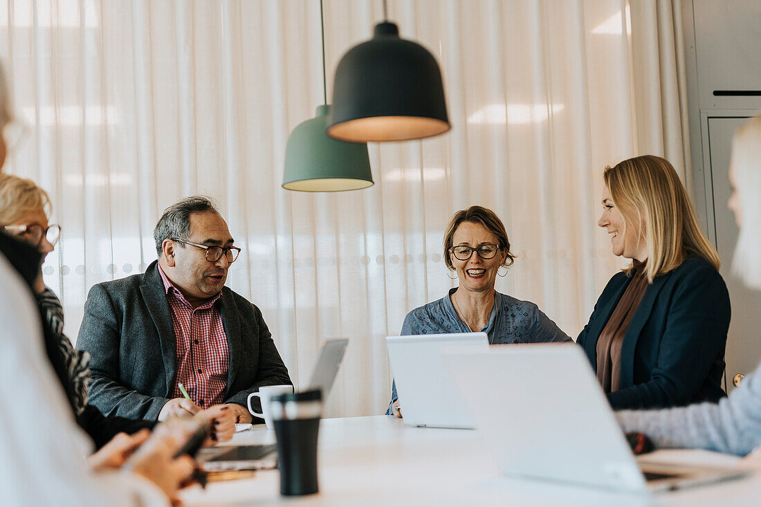 Smiling people talking in office