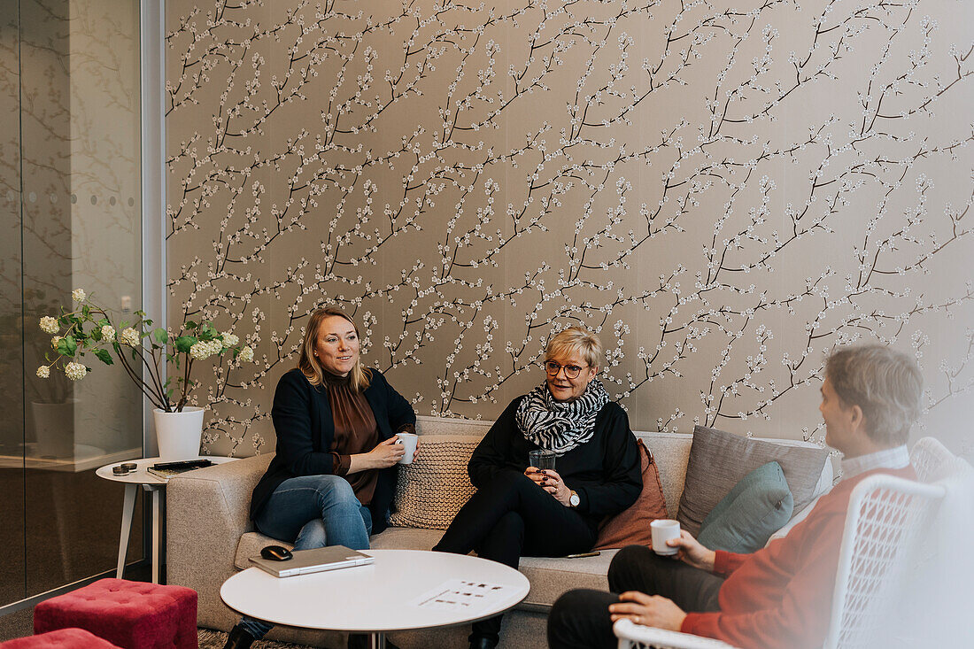 Lächelnde Menschen unterhalten sich in der Büro-Lobby