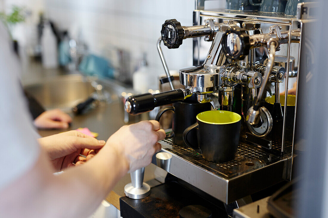 Hands of person using coffee maker