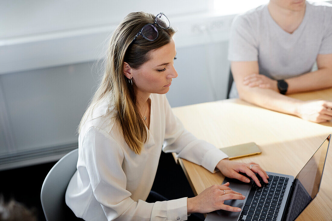 Frau benutzt Laptop während eines Geschäftstreffens