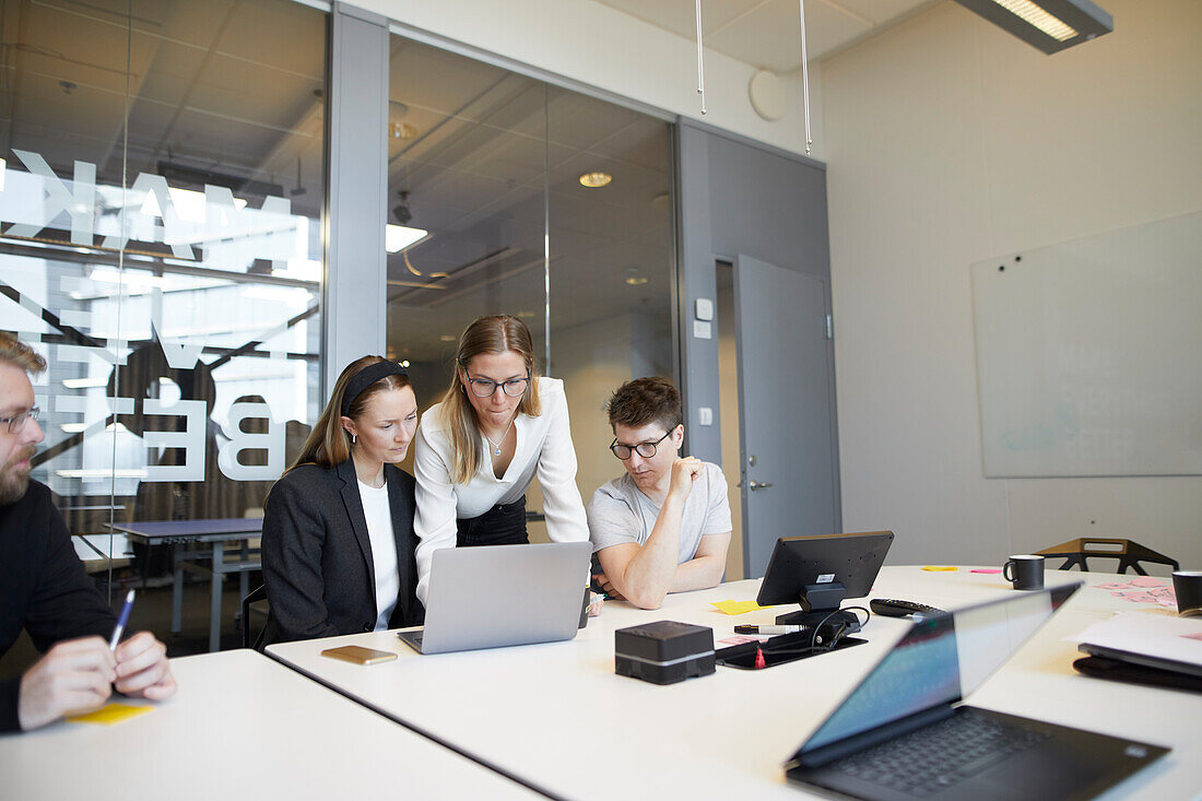 Menschen, die während eines Meetings einen Laptop benutzen