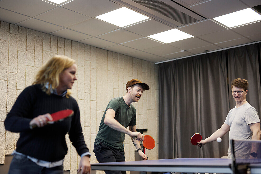 Menschen spielen Tischtennis im Büro
