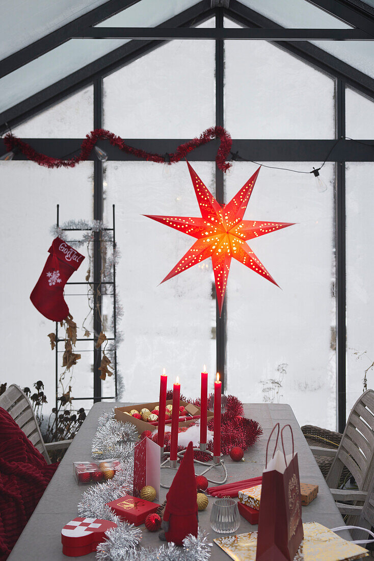 Roter Weihnachtsstern und Dekoration auf dem Tisch