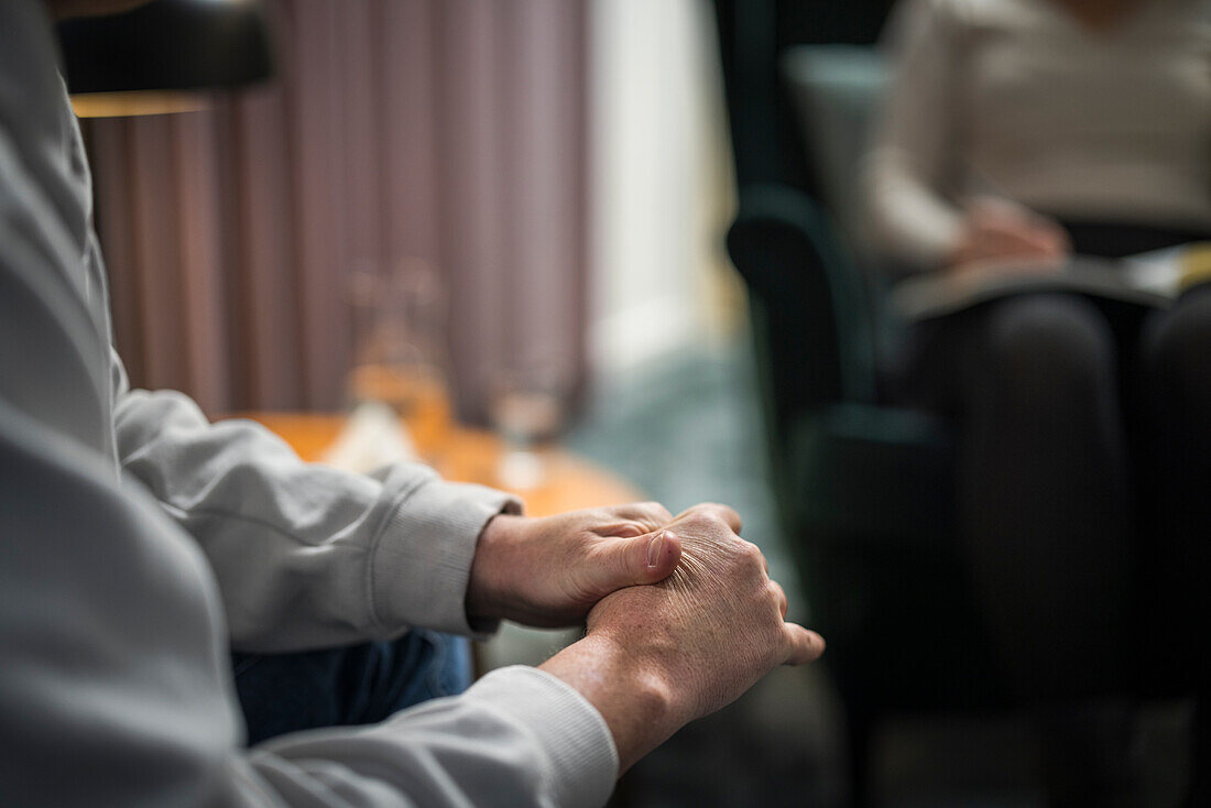 Mann wringt Hände in einer Therapiesitzung aus