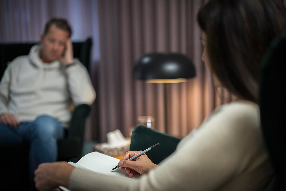 Female doctor taking notes at therapy session