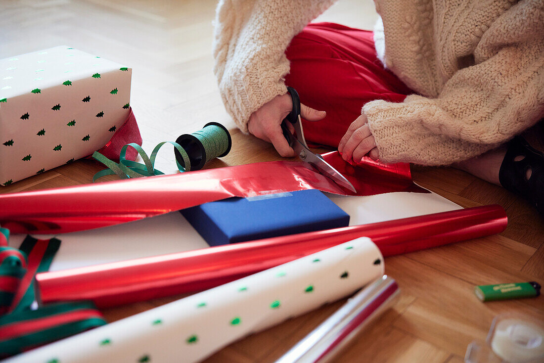 Frauenhände verpacken Weihnachtsgeschenke