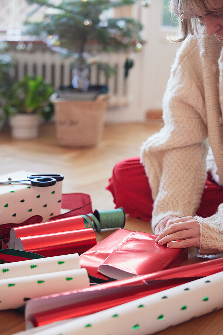 Frauenhände verpacken Weihnachtsgeschenke