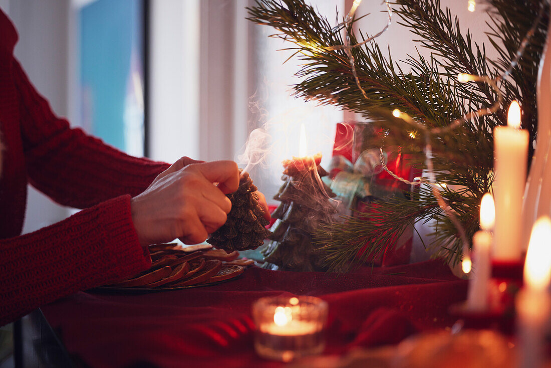 Person lighting Christmas candles at home