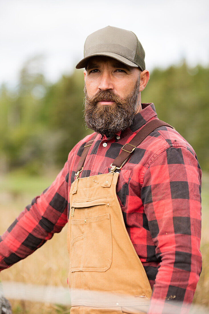 Male farmer in plaid shirt standing outdoors