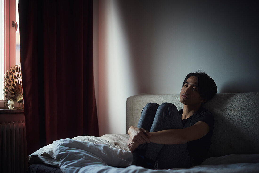 Pensive man sitting on sofa