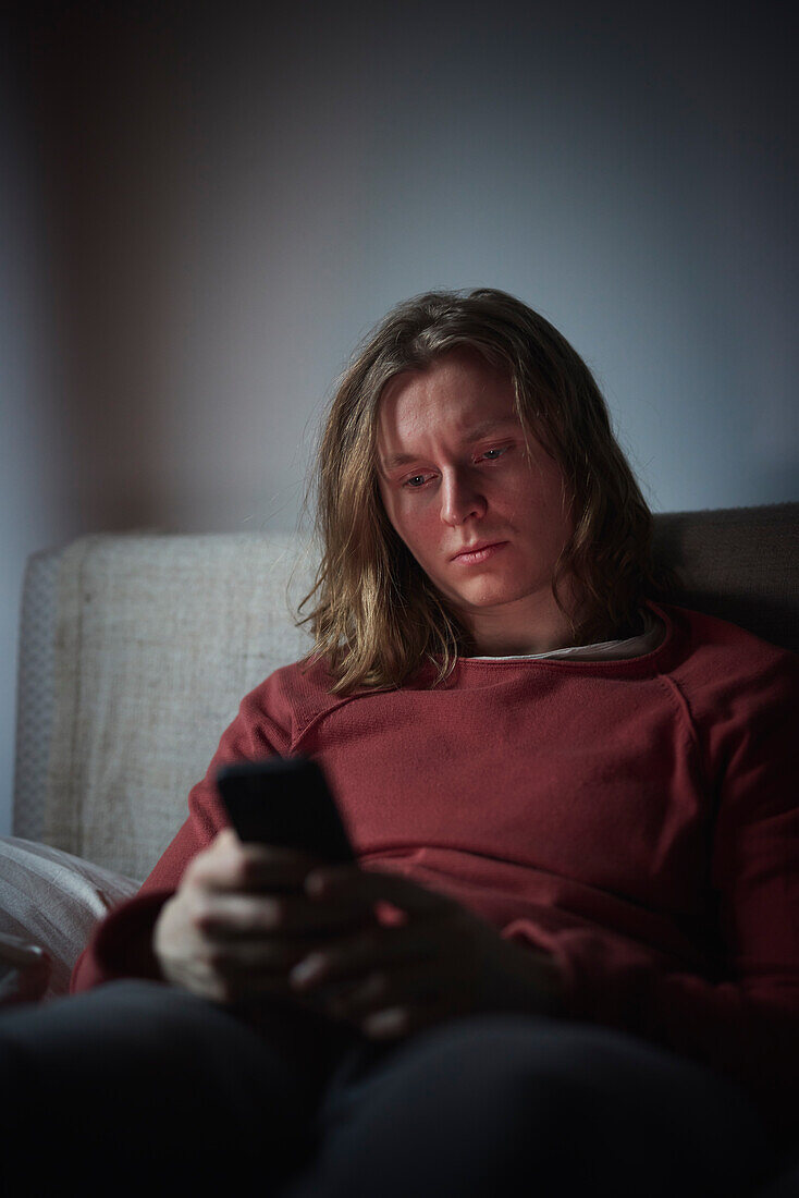 Man on bed using cell phone