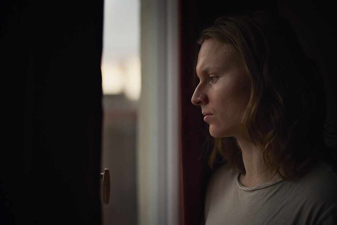 Thoughtful man looking through window