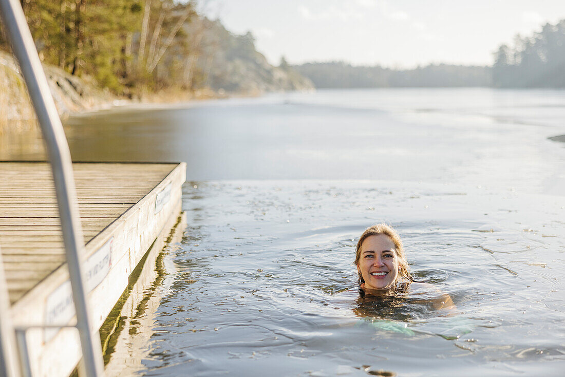 Frau beim Schwimmen im See im Winter