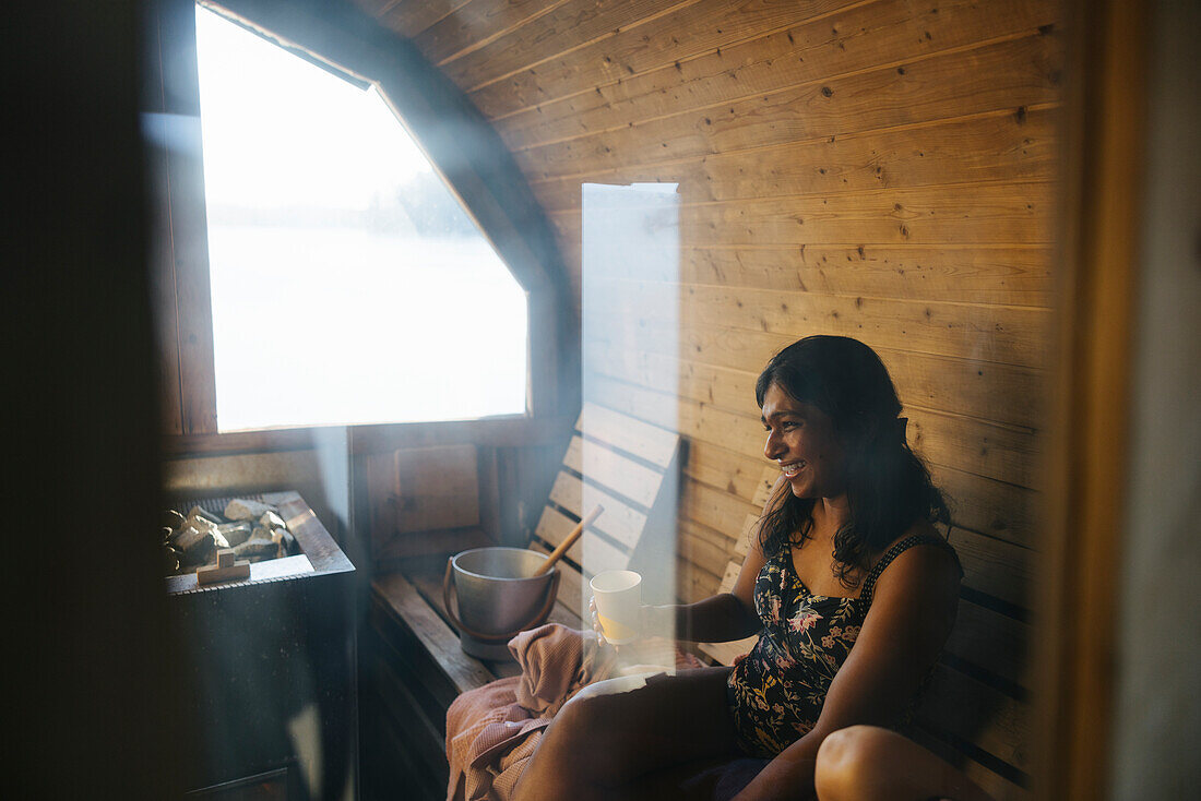 Smiling woman relaxing inn sauna