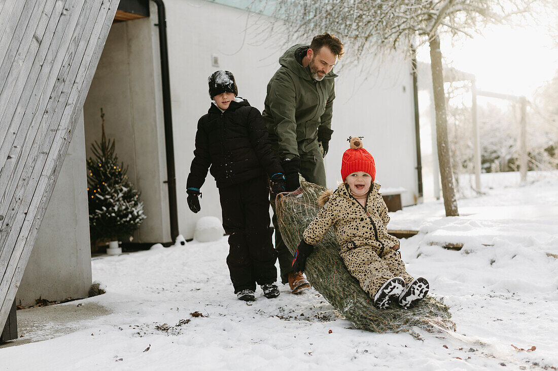 Glückliche Familie im Winter vor dem Haus