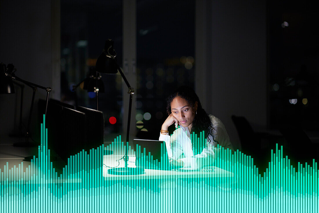 Young businesswoman working in office at night