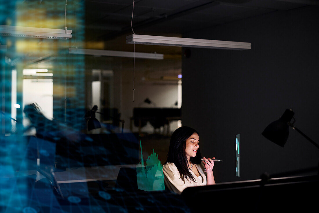 Young businesswoman working in office at night