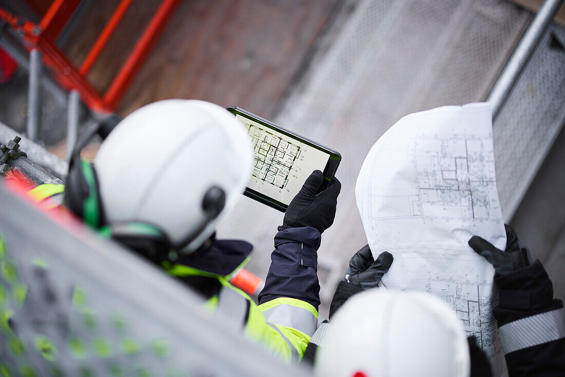 Engineers using digital tablet at building site