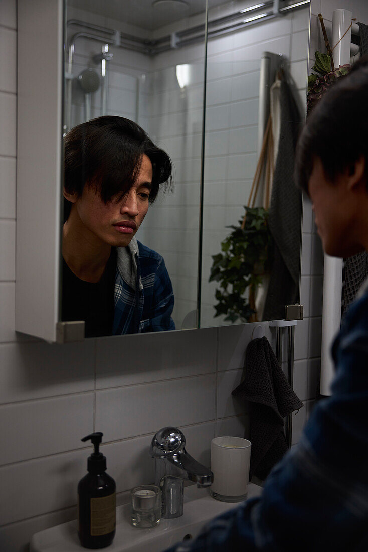 Junger Mann sieht in den Spiegel