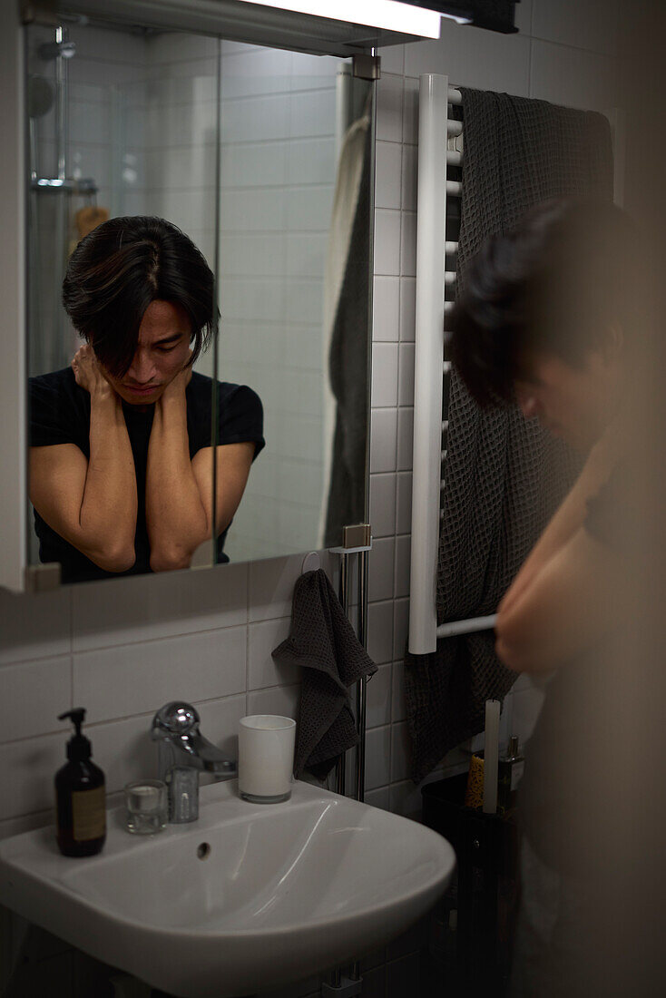 Young man standing in front of mirror