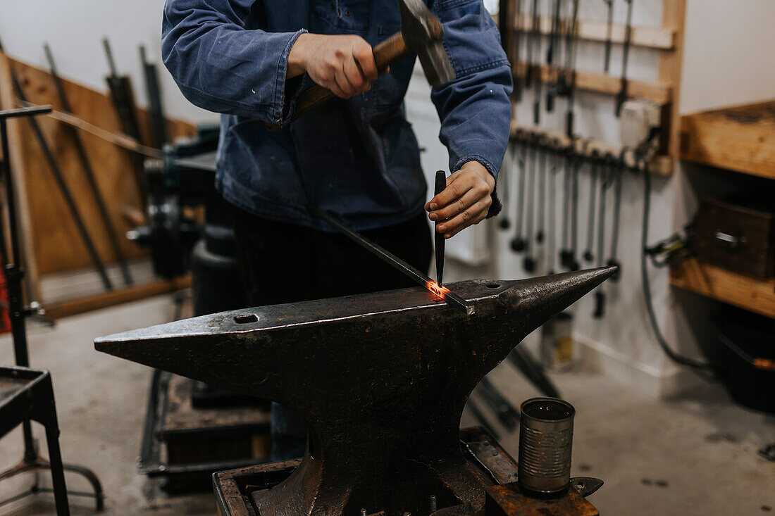 Schmied mit Hammer und Amboss in der Werkstatt