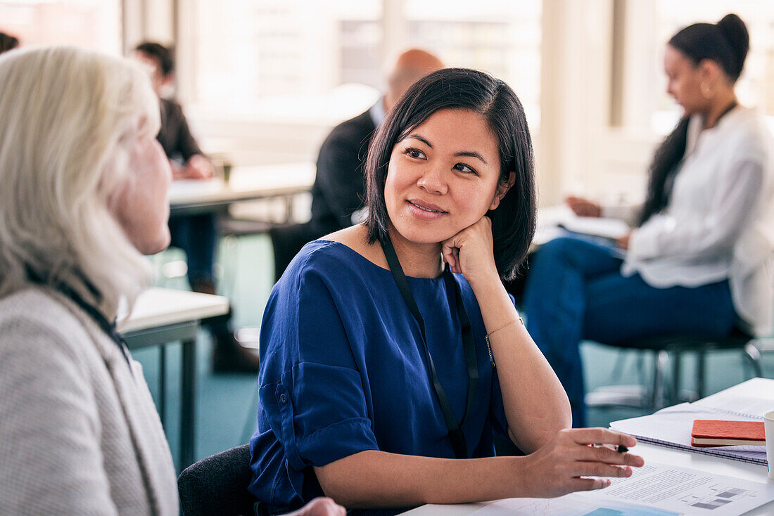 Smiling women sitting together in class