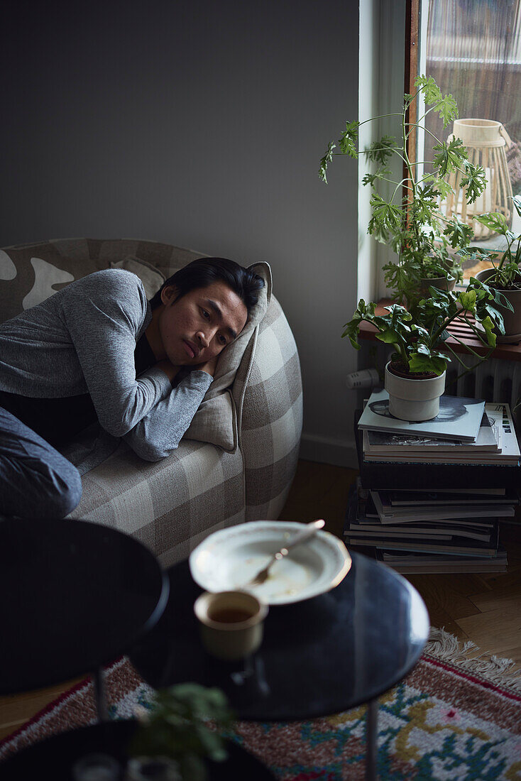 Sad man facing depression lying in bed