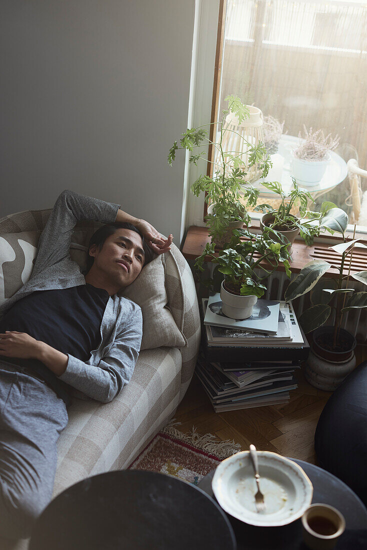 Sad man facing depression lying in bed