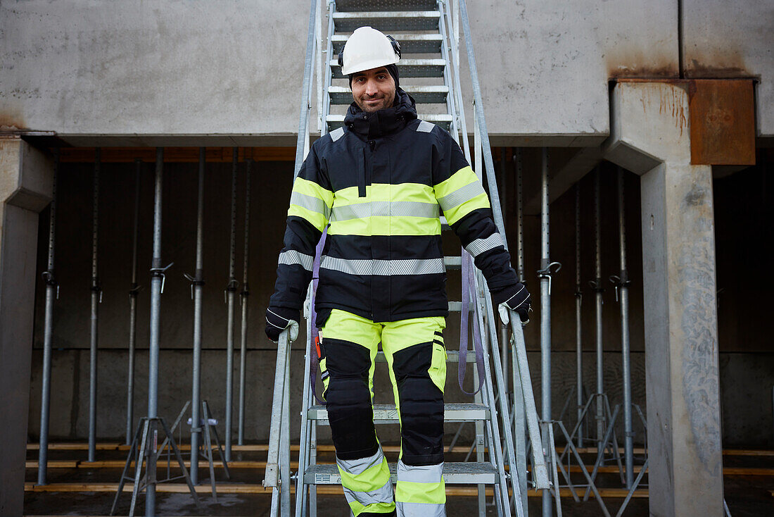 Engineer walking down stairs at construction site