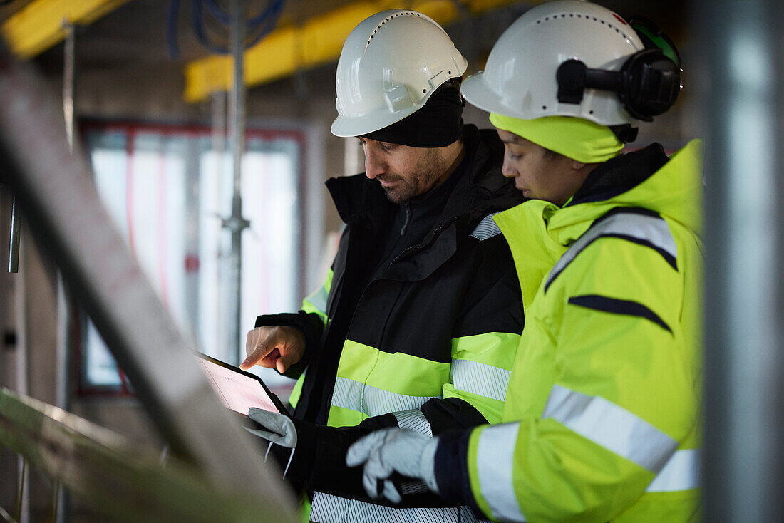 Male and female engineer working at construction site