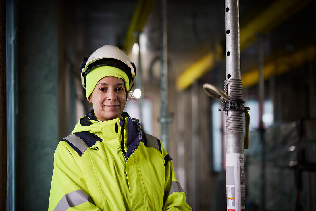 Porträt einer lächelnden Ingenieurin auf einer Baustelle